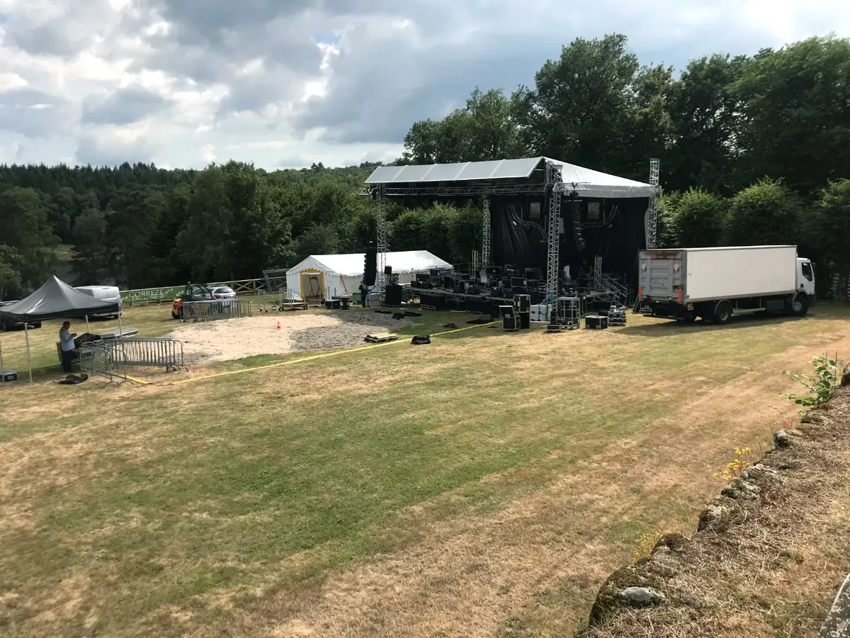 Scène couverte et structures en cours de montage sur un site de plein air